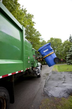 Damaged commercial waste container beside a loading area